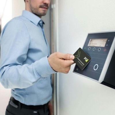 Businessman uses RFID card reader for secure office access, enhancing workplace security.