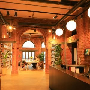 Warm and inviting interior of a public library in İstanbul, T&uuml;rkiye, featuring brick walls and modern lighting.